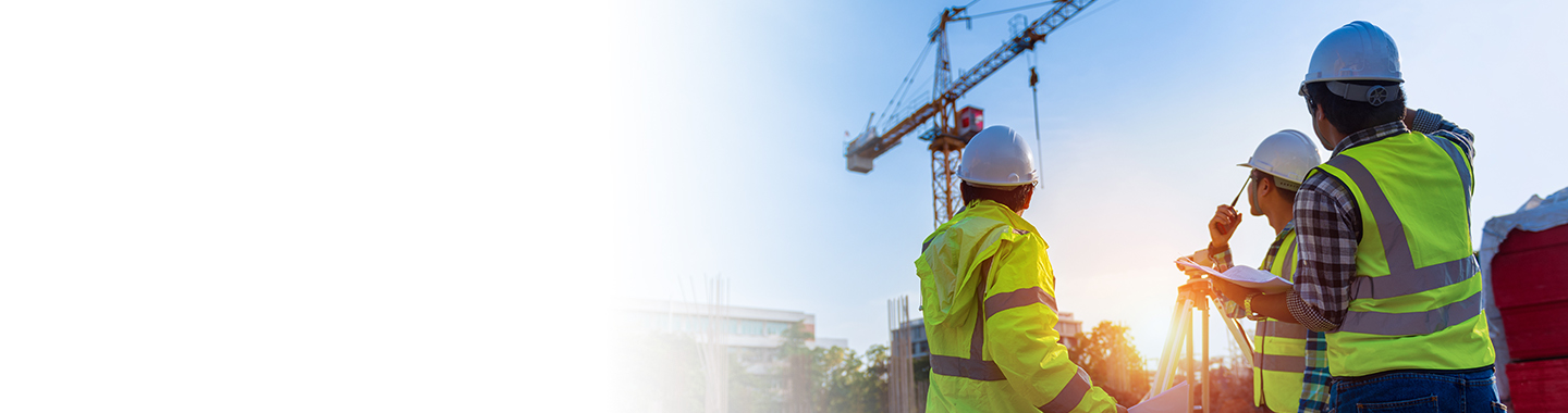Construction workers looking at a large crane.